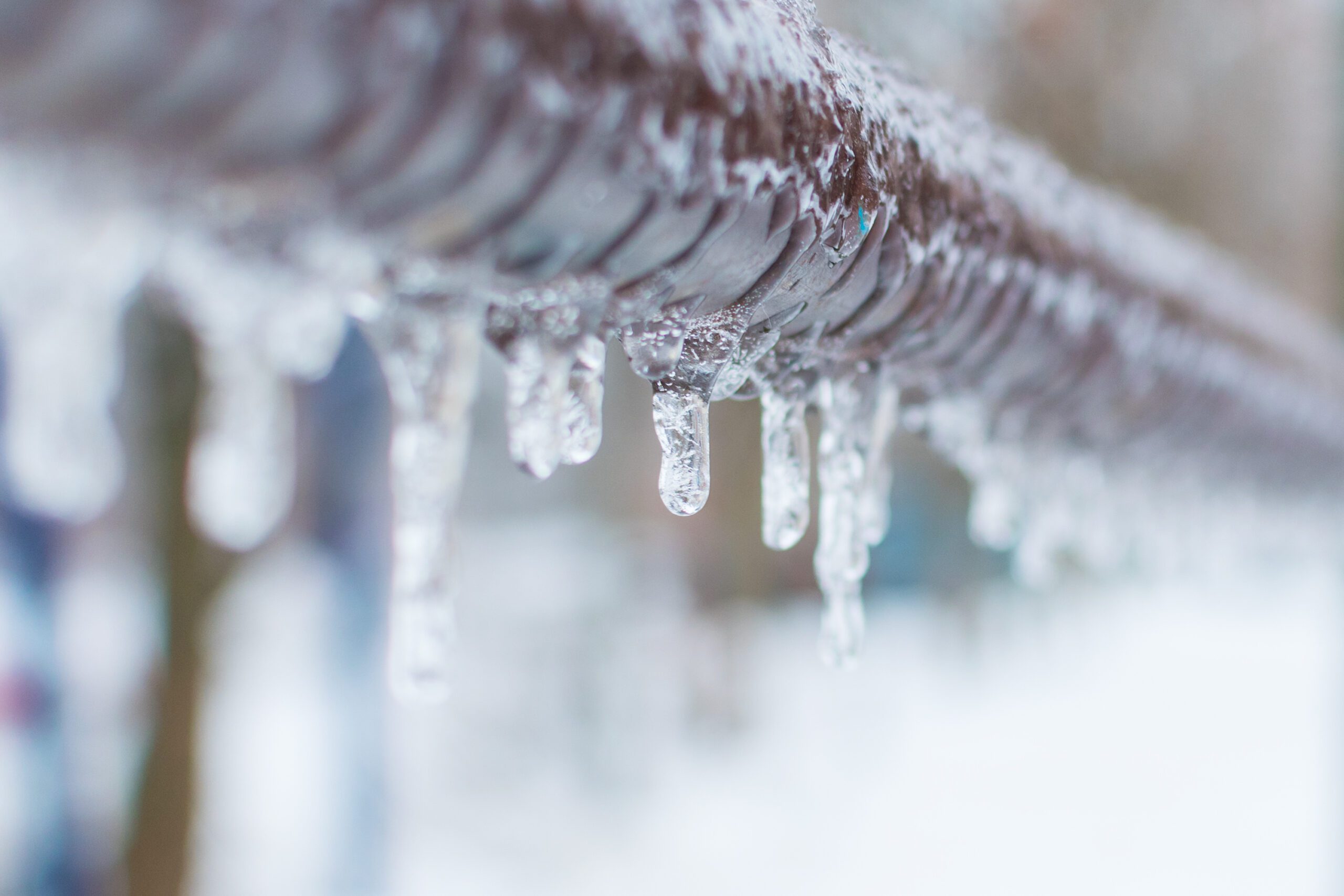 Frozen water pipe covered in ice during winter, showing a common plumbing risk and the importance of preventing frozen pipes